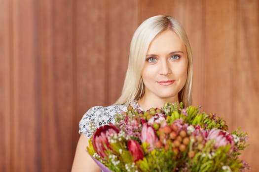 Portrait of a beautiful young woman holding flowers