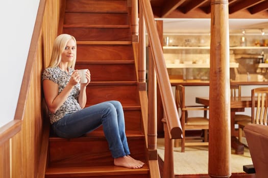 A young woman drinking coffee at home