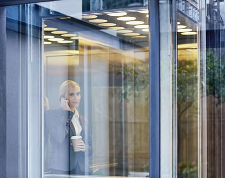 A young businesswoman talking on the phone in elevator