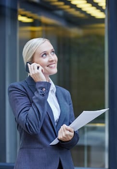 A young businesswoman talking on her cellphone outside