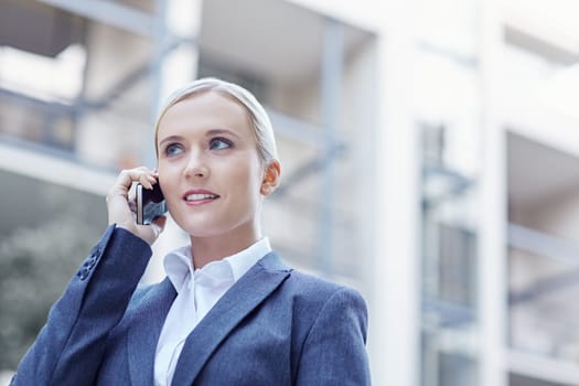 A young businesswoman talking on the phone outdoors
