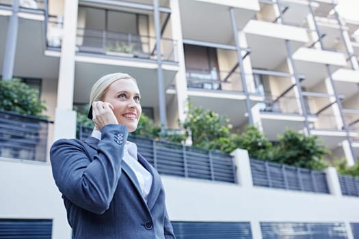 A young businesswoman talking on her cellphone outdoors