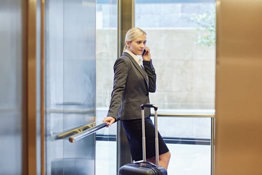 Businesswoman talking on the phone in elevator