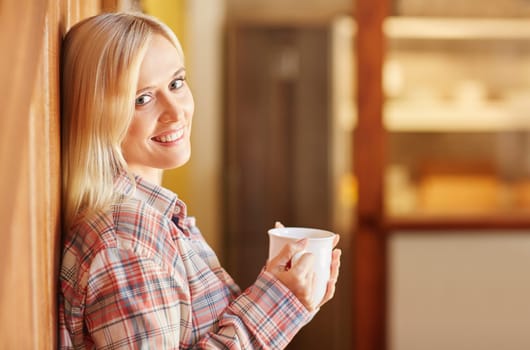 A young woman drinking coffee at home