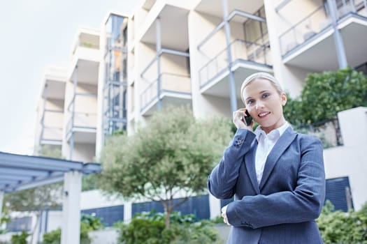 A young businesswoman talking on her cellphone outdoors