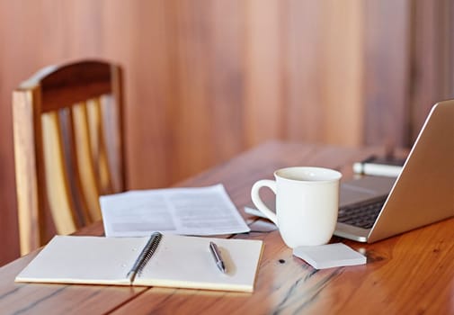 Office workspace with wooden table, laptop and documents