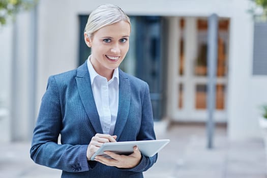A young businesswoman working on her tablet outdoors