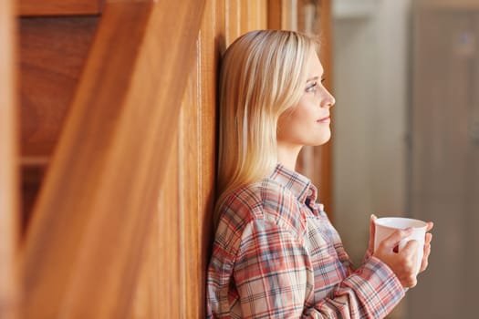 A young woman drinking coffee at home