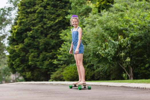 Girls skateboarding home driveway with dogs