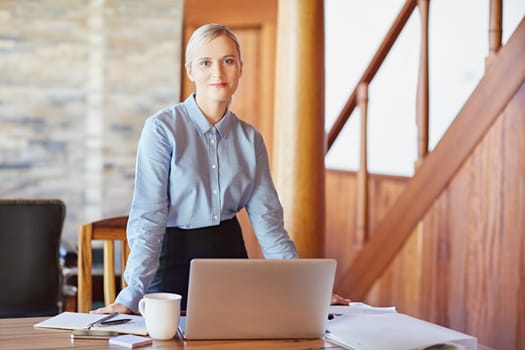 Portrait of a young businesswoman at her desk, looking in to the camera