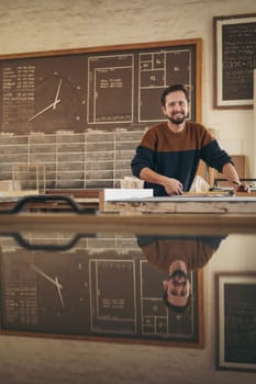 Portrait of a professional craftsman working in his studio on a project