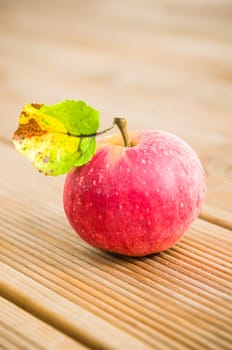 Ripe red apple with a leaf on a blackboard, close-up
