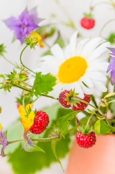 Summer bouquet of forest flowers and strawberries