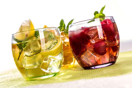 Iced tea with fruits in bulbous low glasses