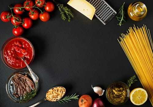 Fresh ingredients for cooking pasta on black background place for text. Vegan food vegetarian and healthy cooking concept.