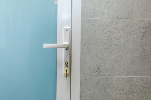 A closeup view of a modern door handle set against a textured wall, drawing attention to its sleek contemporary design