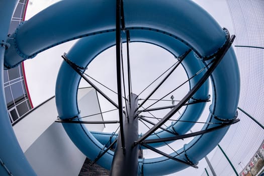 A thrilling view of a stunning blue water slide spiral, highlighting its unique design from an upward angle