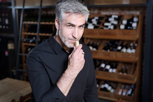 Man poured red wine into a glass. Sommelier selects wine.
