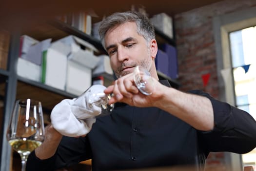 A shot without streaks. Man watches a crystal wine glass.
