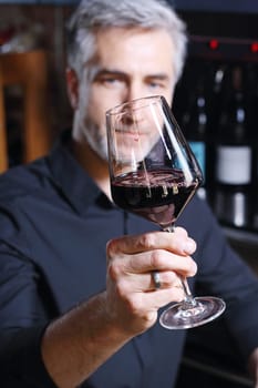 Man poured red wine into a glass. Sommelier selects wine.