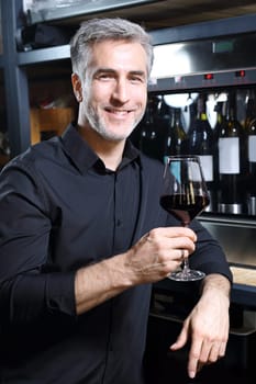 Man poured red wine into a glass. Sommelier selects wine.