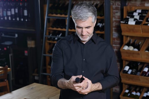 Man poured red wine into a glass. Sommelier selects wine.