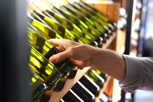 Wine. Man chooses a bottle of wine. Wine cellar