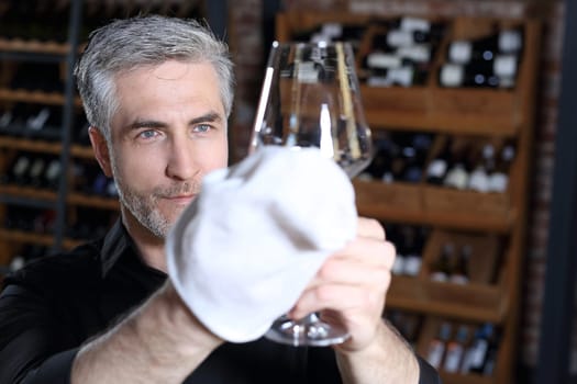 A shot without streaks. Man watches a crystal wine glass.