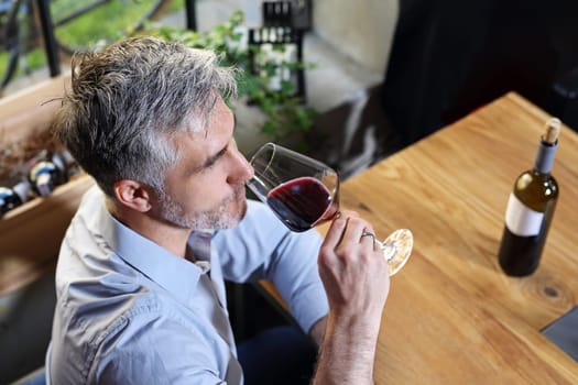 A glass of red wine. Handsome man drinking wine. Man drinking wine.
