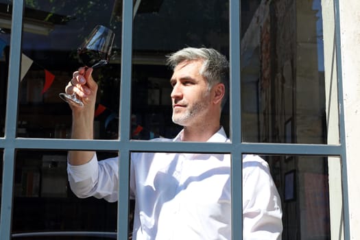 A glass of red wine. Handsome man drinking wine. Man drinking wine.