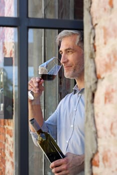 A glass of red wine. Handsome man drinking wine. Man drinking wine.