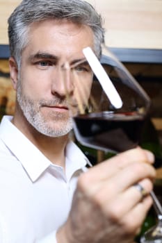 Man poured red wine into a glass. Sommelier selects wine.
