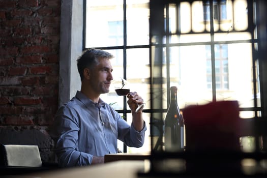 A glass of red wine. Handsome man drinking wine. Man drinking wine.
