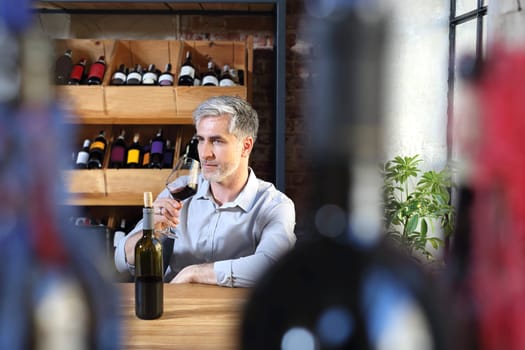 A glass of red wine. Handsome man drinking wine. Man drinking wine.