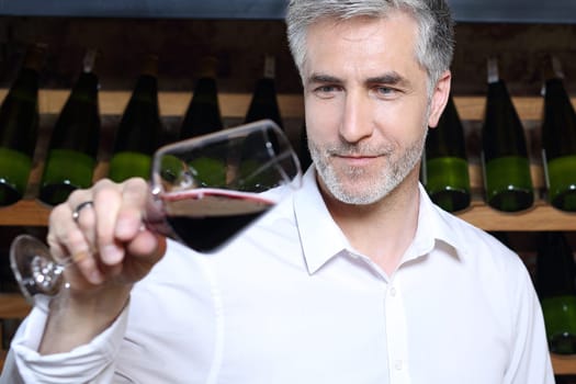 Man poured red wine into a glass. Sommelier selects wine.