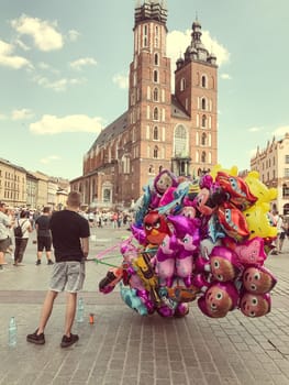 Krakow, Poland - July 29, 2017 : Male street vendor sells colorful popular cartoon character helium balloons