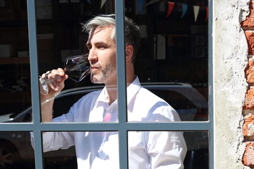 A glass of red wine. Handsome man drinking wine. Man drinking wine.