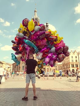 Krakow, Poland - July 29, 2017 : Male street vendor sells colorful popular cartoon character helium balloons