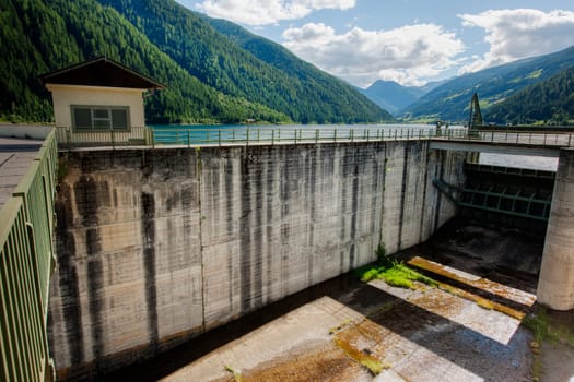 Drainage barrier at the Zoggel reservoir in Ulten in South Tyrol in summer 2017..The Zoggler reservoir is located in the middle of the Ulten Valley,between the villages of St. Walburg and Kuppelwies. The lake draws its water from the Falschau River. The reservoir has a maximum width of 650 meters,is a good 140 hectares in size and has a storage capacity of 33,100,000 m³. This makes it the largest energy supplier in Val d'Yulate.