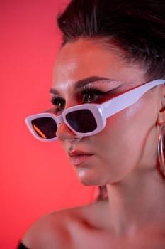 An eyecatching and striking portrait of a stylish woman donning trendy sunglasses set against a vibrant background