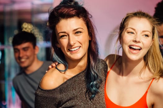 Happy women are dancing together in a nightclub.