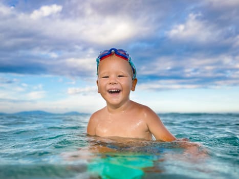 Cute boy plays in a sea
