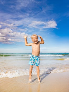 Cute boy jumping on the beach