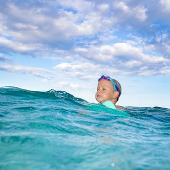 Cute boy plays in a sea