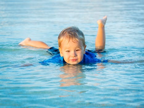 Cute boy plays in a sea