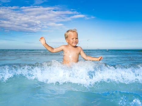 Cute boy plays in a sea