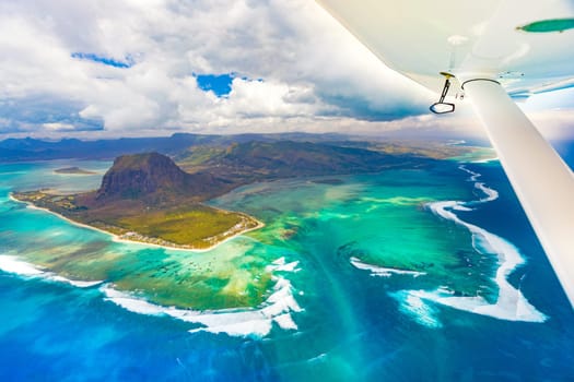 Aerial view of the underwater waterfall. Plane wing on the foreground. Mauritius