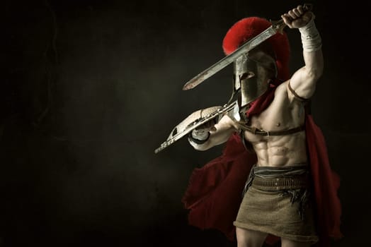 Ancient warrior or Gladiator posing over a dark background