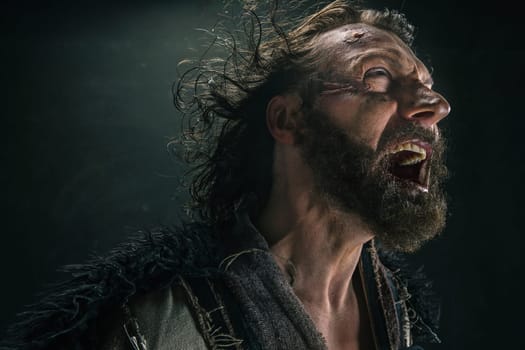 Portrait of a brutal bald-headed viking in a battle mail posing against a black background. Early medieval period.