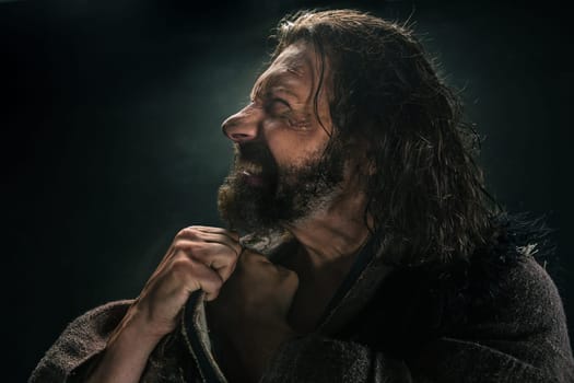 Portrait of a brutal bald-headed viking in a battle mail posing against a black background. Early medieval period.
